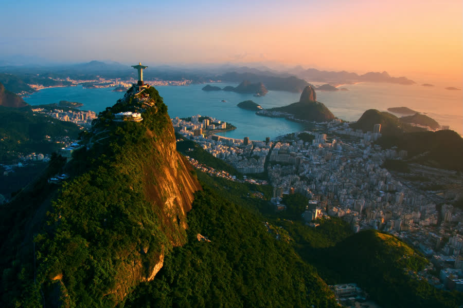 Cristo Redentor no topo do Corcovado, com a Baía de Guanabara e o Pão de Açúcar ao fundo, Rio de Janeiro